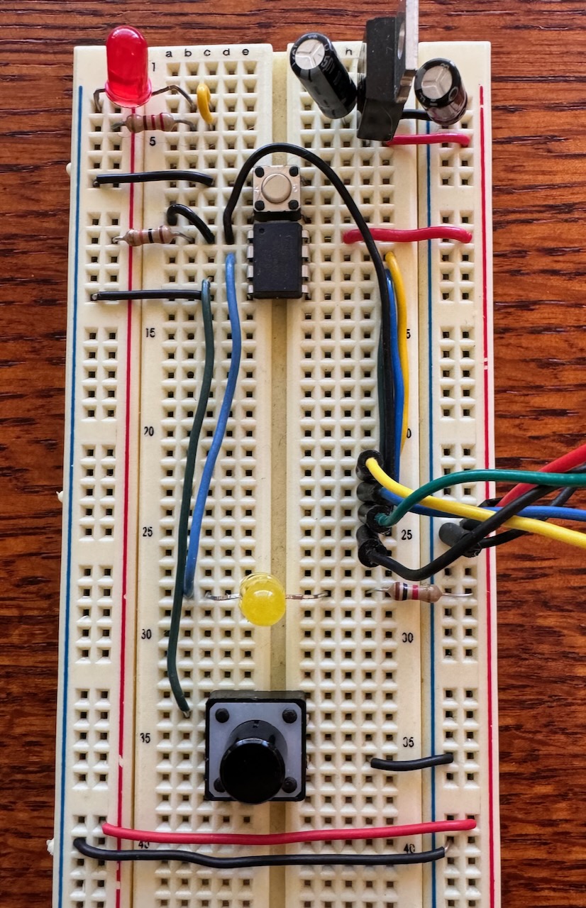Image of the breadboard with the ATtiny, a power circuit, 2 LEDs, two tact switches and a mess of wires.